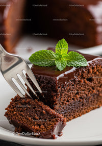 Close up of a moist chocolate cake slice with mint garnish