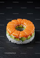 Fresh salmon and avocado sushi ring on black slate