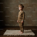 Thoughtful toddler standing barefoot on cozy knit rug