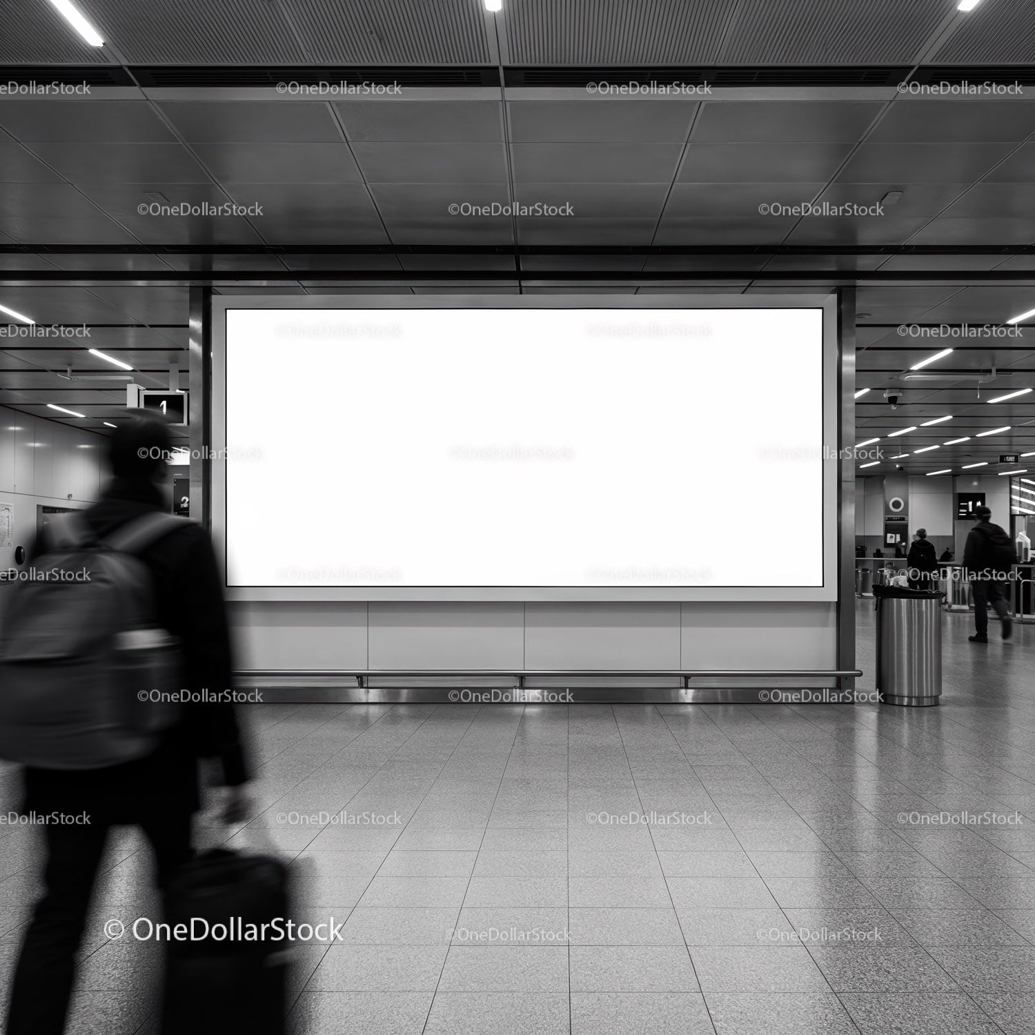 Traveler walking past blank advertising billboard in subway station