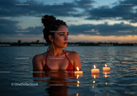 Woman in Black Bikini with Candles Floating in Lake at Sunset