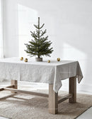 Minimalist spruce tree with golden ornaments on table