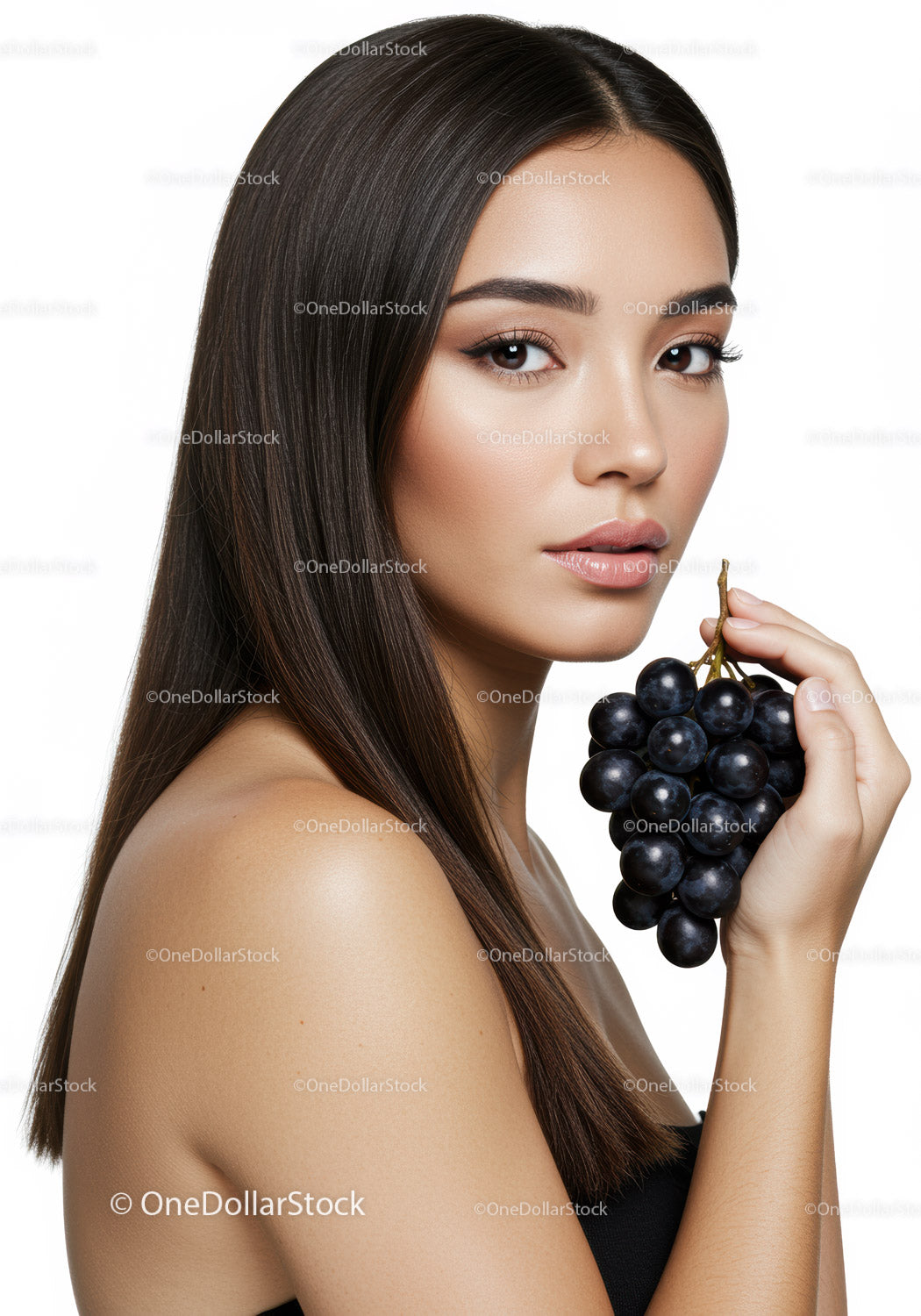 Elegant Woman with Dark Hair Holding Grape Bunch in Studio Portrait