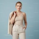 Stylish Young Woman in Beige Tank Top and Cream Trousers on Light Blue Background