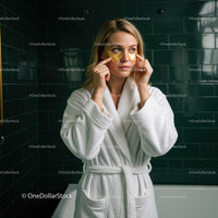 Young Woman Applying Eye Patches in Spa or Bathroom Setting