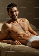 Smiling man relaxing shirtless on bed in natural light
