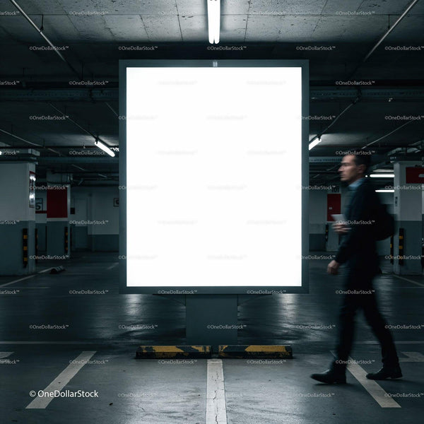 Man walking past illuminated blank billboard in parking garage JPG Mockup Image