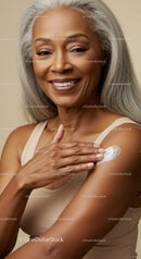 Elegant Elderly Woman Applying Sunscreen with a Warm Smile