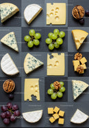 Variety of cheeses with fruits and nuts on slate board