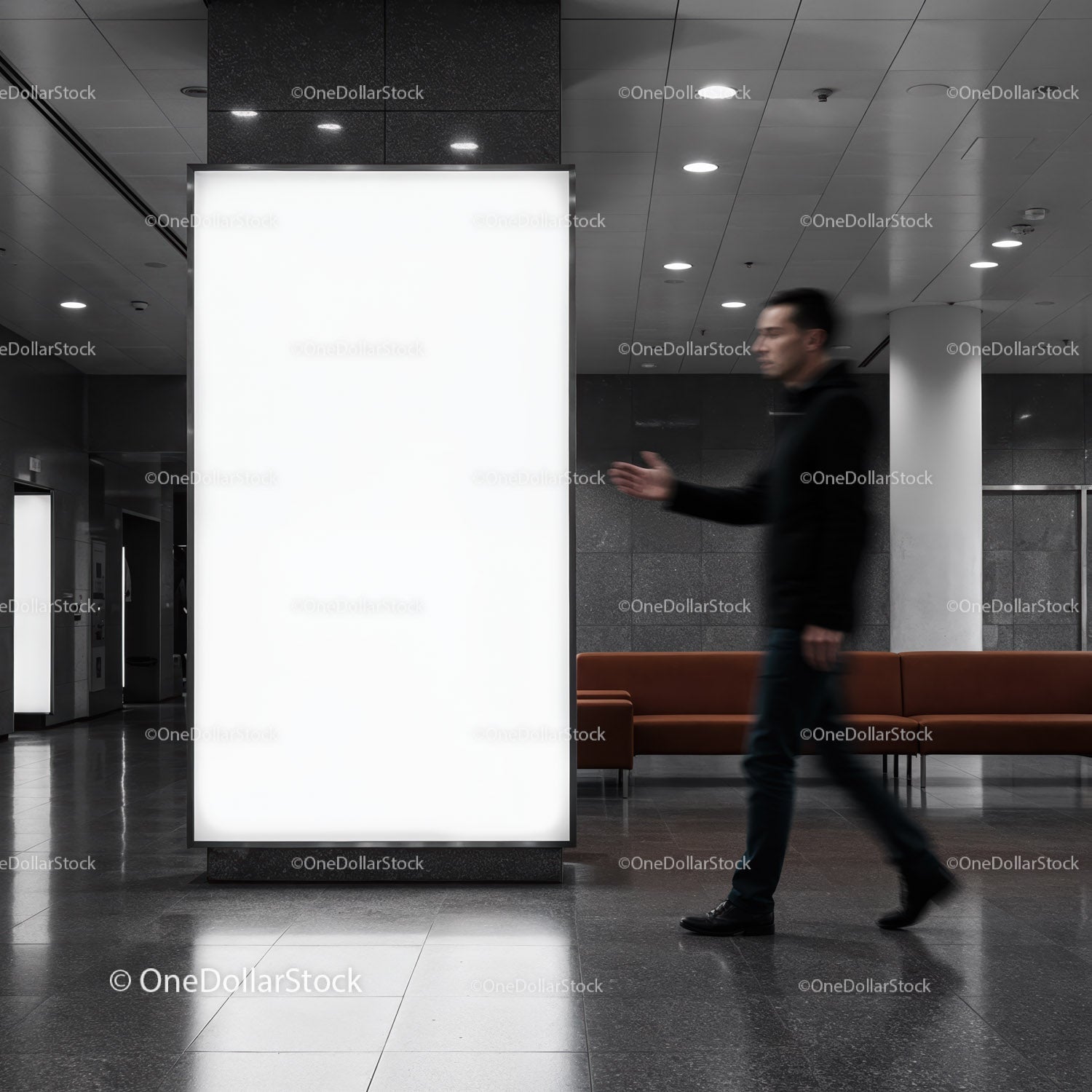 Mężczyzna przechodzący obok dużej podświetlanej tablicy reklamowej w pomieszczeniu