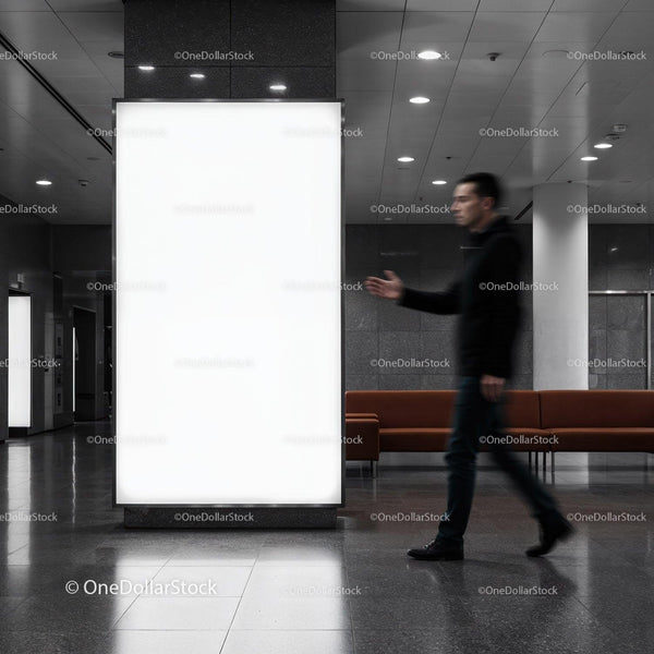 Man Walking Past Large Illuminated Advertising Board Indoors JPG Mockup Image