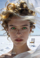 Close-up portrait of young woman with curly hair and green eyes