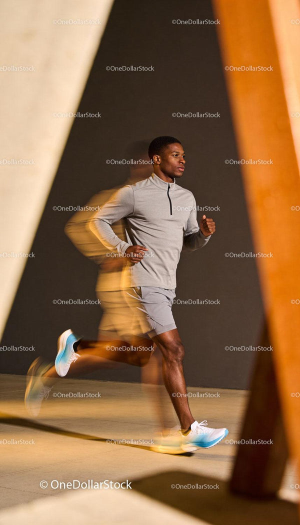 Focused young runner training indoors with motion blur