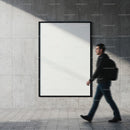 Man walking past empty poster on urban concrete wall