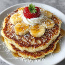 Pancake with Sliced Banana Strawberry Whipped Cream and Caramel Drizzle