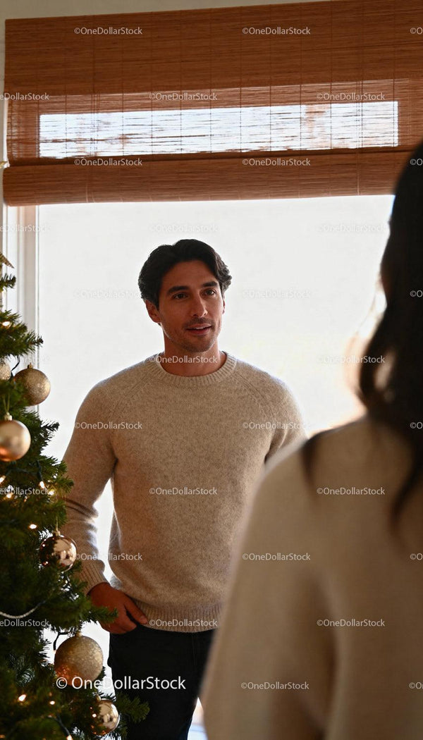 Man in cozy sweater near decorated Christmas tree