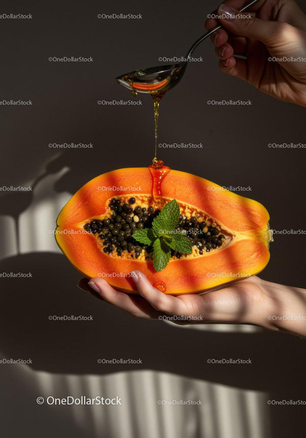 Honey Drizzling Over Fresh Papaya with Mint Leaves