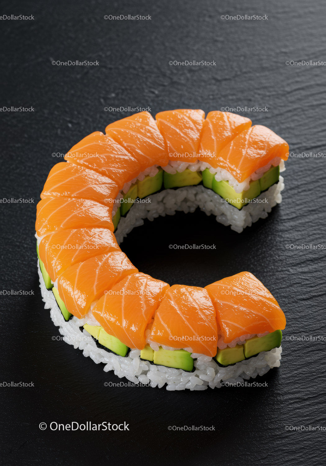 Fresh salmon avocado sushi roll on black slate