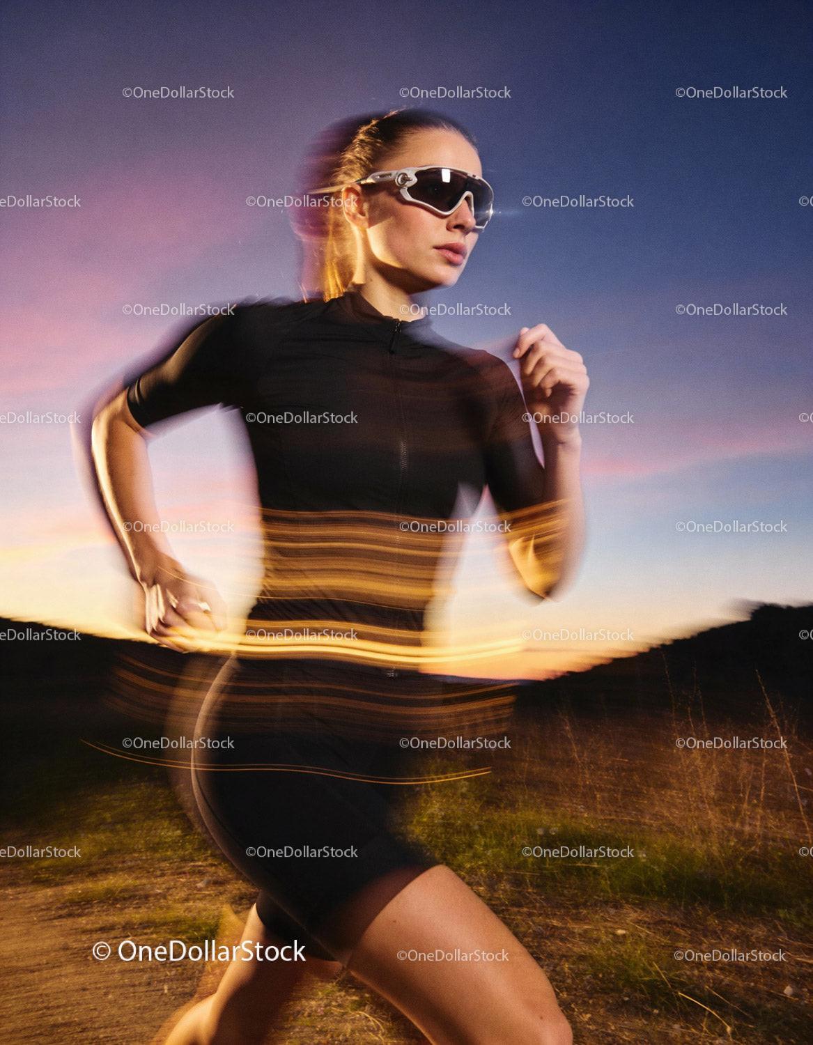 Female Runner Jogging Outdoors at Sunset in Black Gear