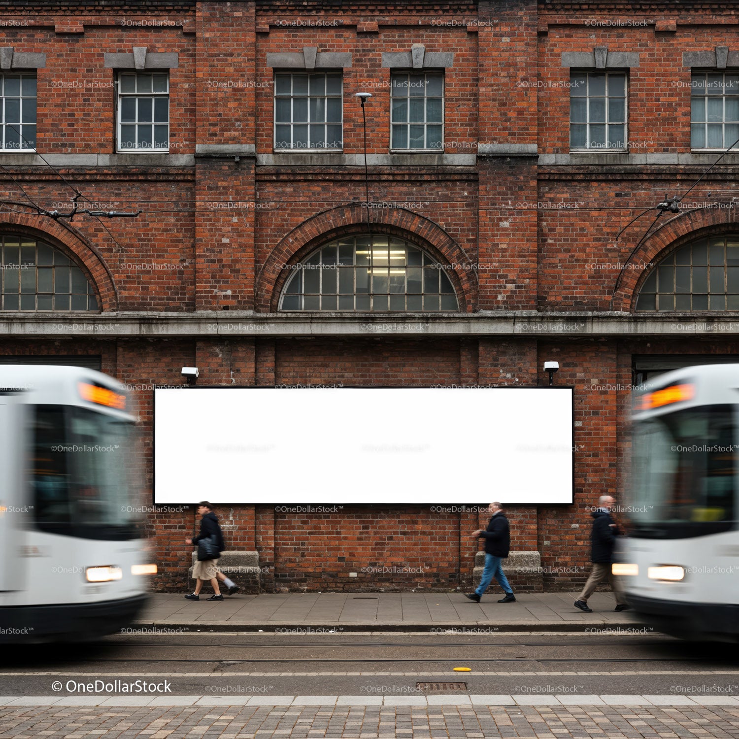 Pusty billboard na ceglanej ścianie z przejeżdżającymi tramwajami i pieszymi