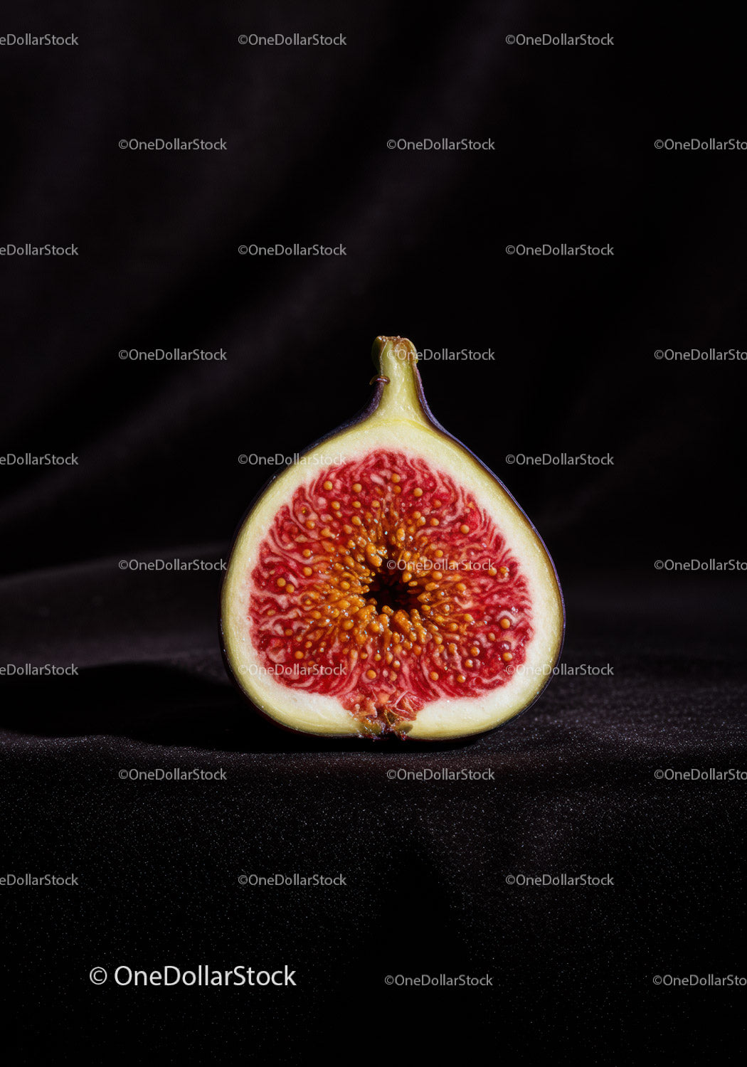 Close up of ripe fig cut in half on dark background