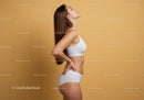 Healthy Woman in White Sportswear Posing in Relaxed Profile Against Yellow Background