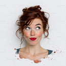Red haired woman with freckles and bright red lipstick in playful pose