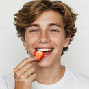Joyful Teen Boy Smiling with Strawberry Close-up