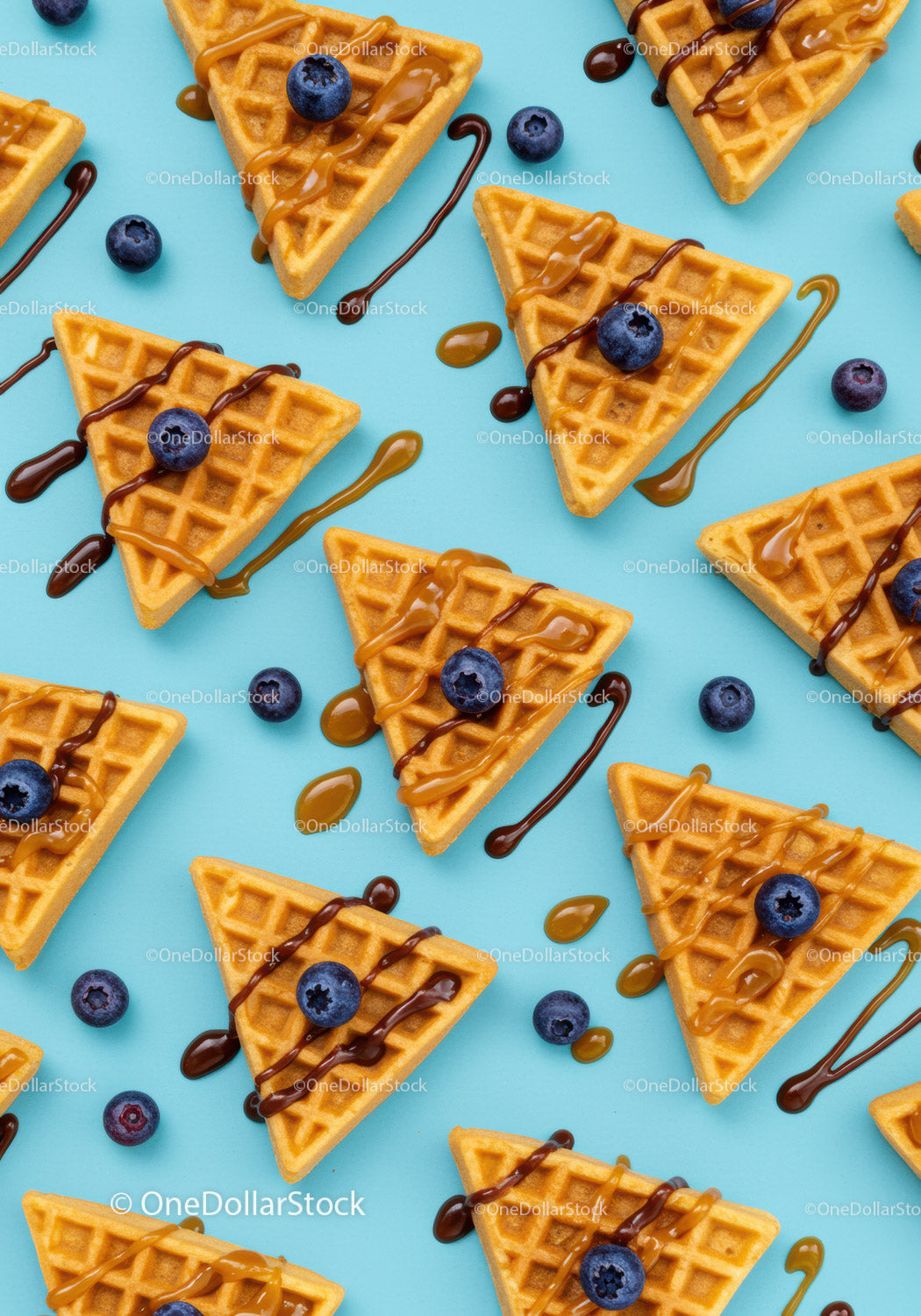 Golden waffles with blueberries and drizzled sauces