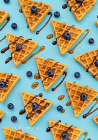 Golden waffles with blueberries and drizzled sauces
