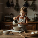 Little girl pouring water in rustic kitchen bowl