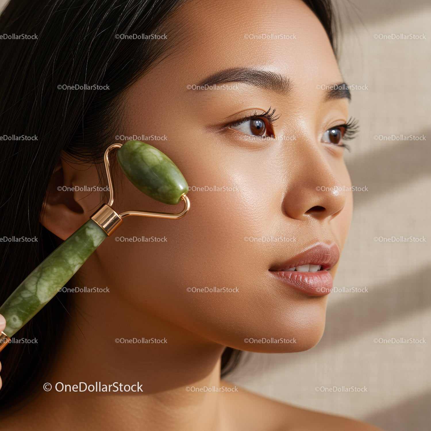 Close-up of a woman using jade roller for facial skincare therapy