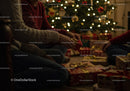 Family wrapped gifts by Christmas tree glowing lights
