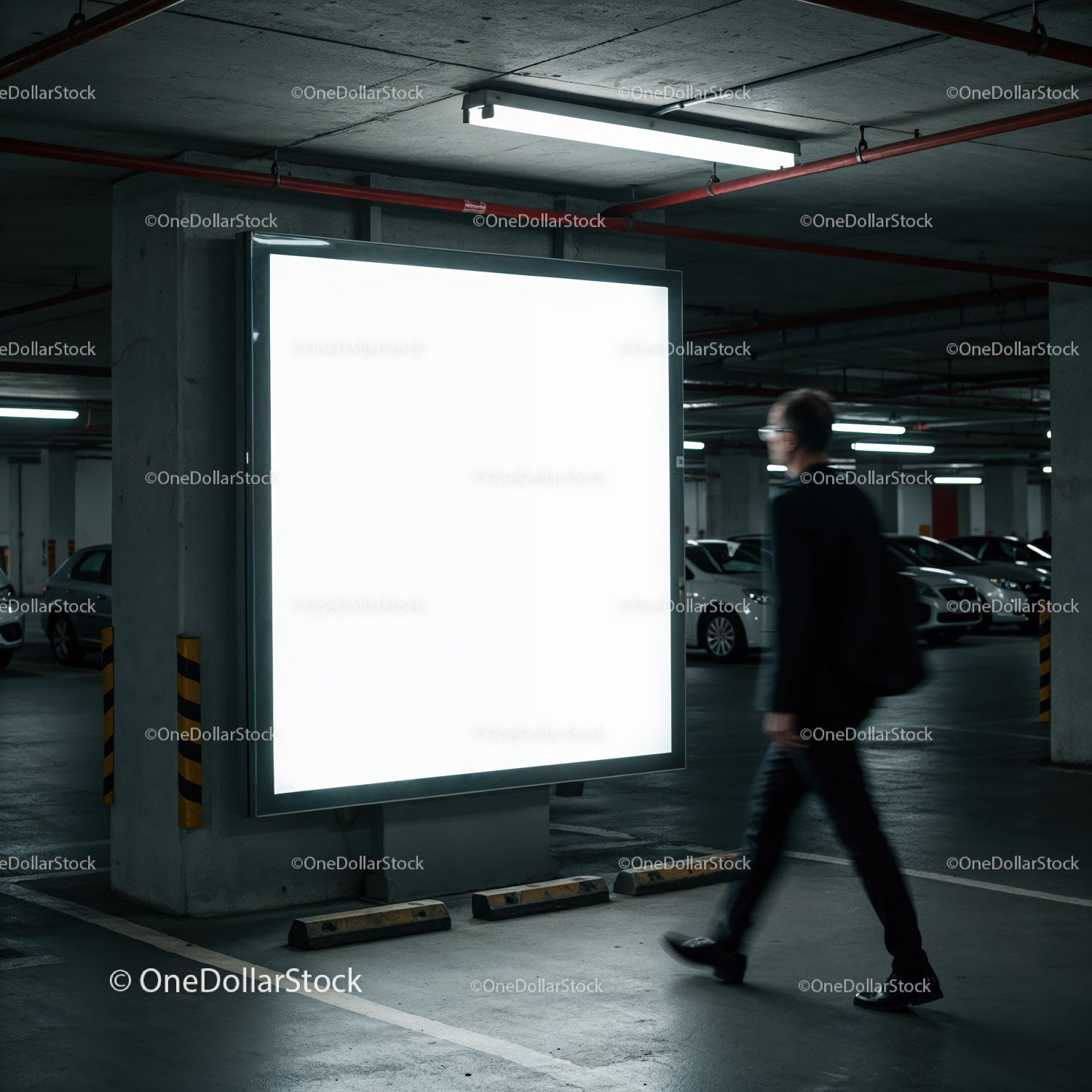 Mężczyzna przechodzący obok oświetlonego billboardu w garażu