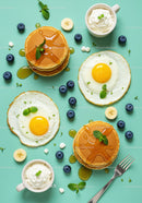 Stacked pancakes with fried eggs and fresh blueberries