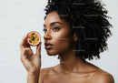 Elegant Black Woman Holding Passion Fruit with Curly Hair