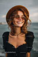 Smiling Woman Wearing Sunglasses and Hat on Beach During Sunset