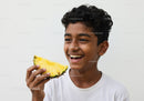 Smiling Boy Holding Pineapple in Bright Summer Setting