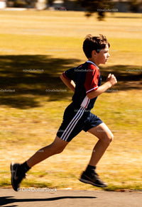 Young boy running energetically in park on sunny day