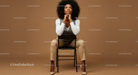 Thoughtful Woman Seated in Elegant Attire Against Brown Background