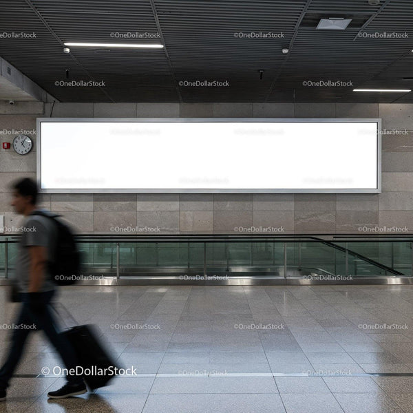 Traveler walking past blank advertisement board in terminal JPG Mockup Image