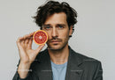 Stylish Man Holding Blood Orange Half in Modern Portrait