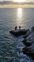 Sunset over the Ocean with Rocky Coast and Silhouetted Figures
