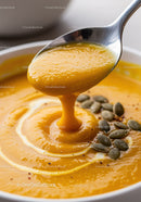 Creamy pumpkin soup with pumpkin seeds close up