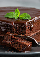 Moist chocolate cake slice with glossy ganache and mint