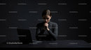 Thoughtful Woman at Laptop in Dark Modern Workspace