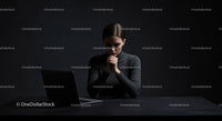 Thoughtful Woman at Laptop in Dark Modern Workspace