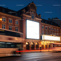 Historic theater facade with bright billboard at night