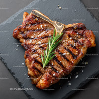 Gourmet Grilled Steak with Rosemary on Black Slate Plate