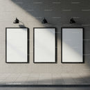 Three blank posters on modern stone wall with lights